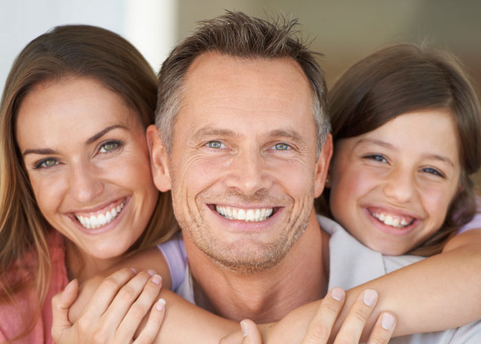 Husband, Wife, and daughter smiling